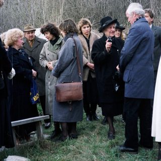 Group of people gathered outdoors near a building.
