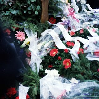 Floral tribute with plaque at a memorial or gravesite.