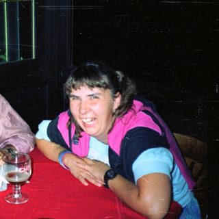 Here's a brief summary of the image: Two people sit at a table, smiling and relaxed.