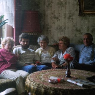 Group of people seated on a vintage sofa.