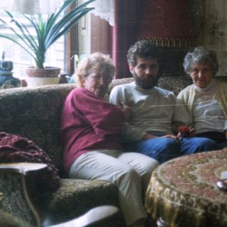 Group of people seated on a vintage sofa.