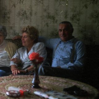 Group of people seated on a vintage sofa.