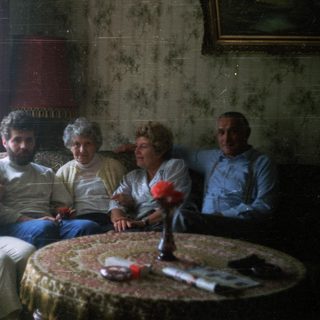 Group of people seated on a vintage sofa.