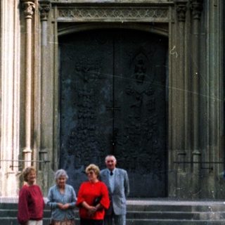 People stand before a large, ornate church entrance.