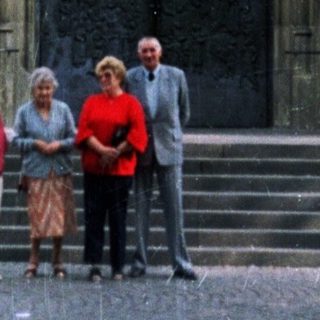 People stand before a large, ornate church entrance.