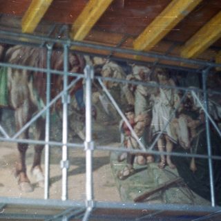 Mural depicting figures, likely biblical, with scaffolding overhead.
