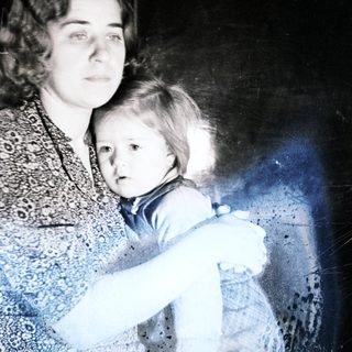 A woman holds a baby in her arms.