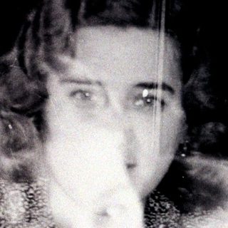 Here's a brief summary of the image: A woman and child, captured in a blurred, vintage photograph.