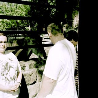 People observing animals through a fence at a zoo.