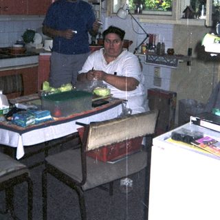 Man preparing food in a kitchen with a window.