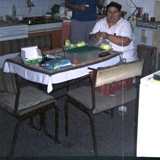 Man preparing food in a kitchen with a window.