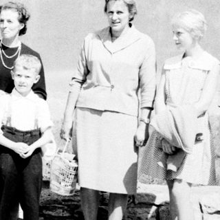Family portrait featuring John F. Kennedy and several women and a child.