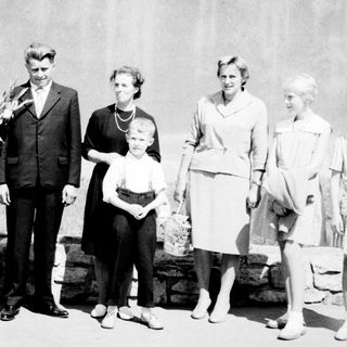 Family portrait featuring John F. Kennedy and several women and a child.