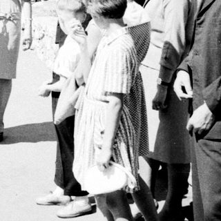 Group of people conversing outdoors in a black and white photo.