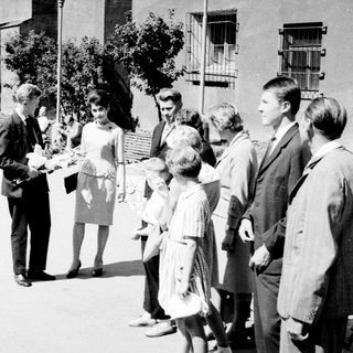 Group of people conversing outdoors in a black and white photo.