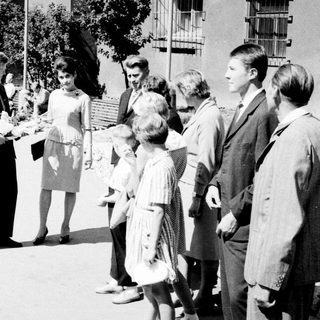 Group of people conversing outdoors in a black and white photo.
