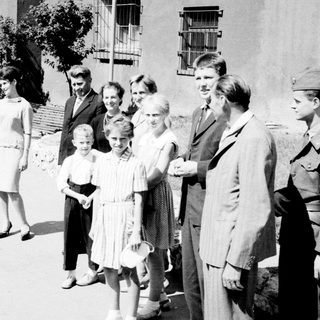 Group of people standing on a street, possibly posed.
