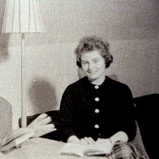 Man and woman sit reading, next to a lamp.