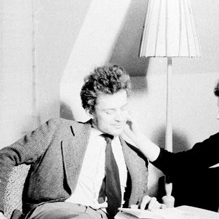 Man and woman seated, appearing to discuss something intently.
