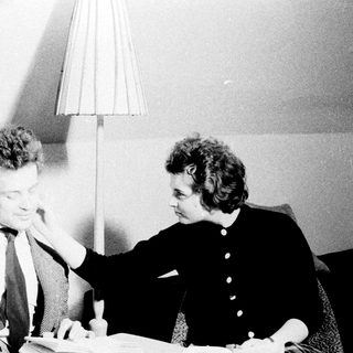 Man and woman seated, appearing to discuss something intently.