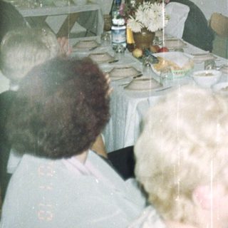 Banquet hall with tables set, stage, and audience present.