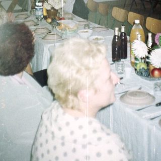 Banquet hall with tables set, stage, and audience present.
