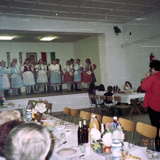 Group performance on stage with audience seated at tables.