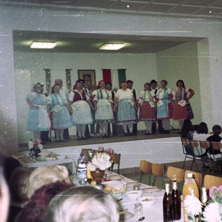 Group performance on stage with audience seated at tables.