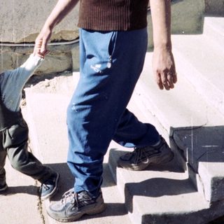 Man walks down stairs, assisting a toddler.