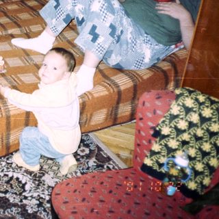 Elderly woman, child, and young adult in a living room.
