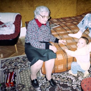 Elderly woman, child, and young adult in a living room.