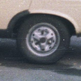 Boy stands next to car, truck with "BUSCH" logo.