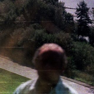 Person overlooking a river valley with mountains in the distance.