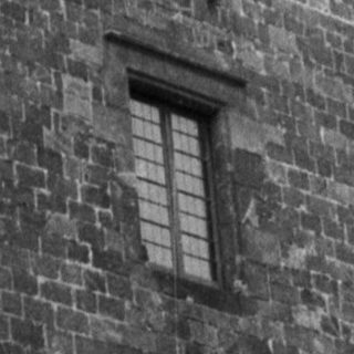 Black and white image of a stone building facade.