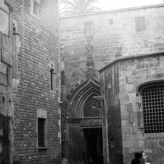 Black and white photo of a historic stone building and walkway.