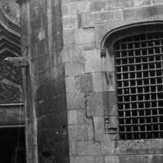 Black and white photo of a historic stone building and walkway.