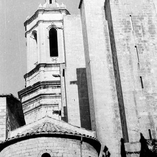 Here's a brief summary of the image: Stone church with tower and visible shadows.