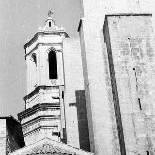 Here's a brief summary of the image: Stone church with tower and visible shadows.