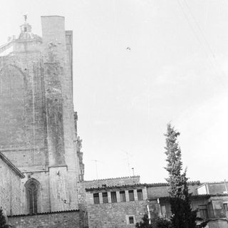 Black and white image of a church tower and buildings.
