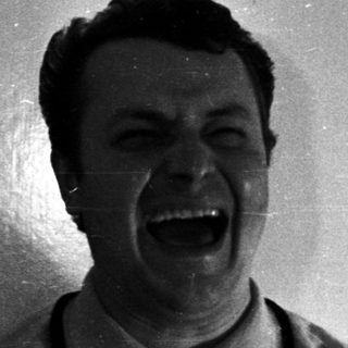 Man with a wide, open mouth against a door.