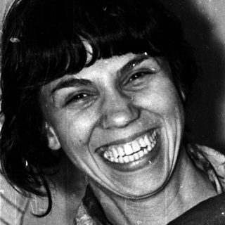 Black and white photo shows a smiling woman with a man.