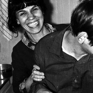 Black and white photo shows a smiling woman with a man.