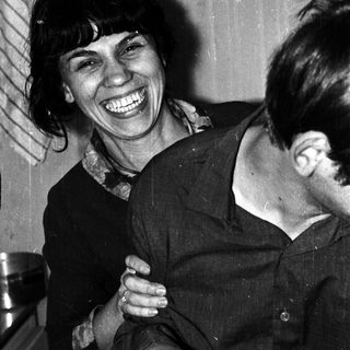 Black and white photo shows a smiling woman with a man.