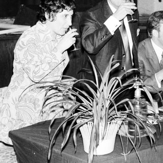 Group of people socializing with drinks at a table.