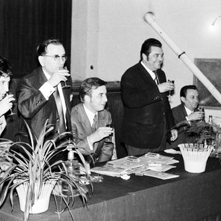 Group of people socializing with drinks at a table.
