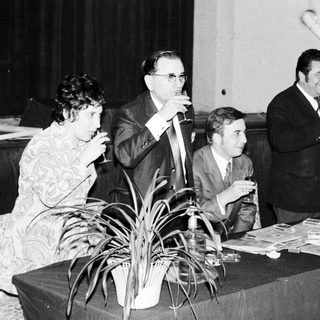 Group of people socializing with drinks at a table.