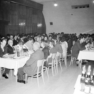 Group of formally dressed people dining at a large table.