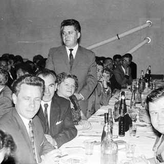 Group of people seated at a table during an event.