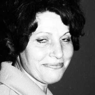 Black and white portrait of a woman smiling slightly.