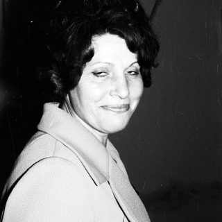 Black and white portrait of a woman smiling slightly.